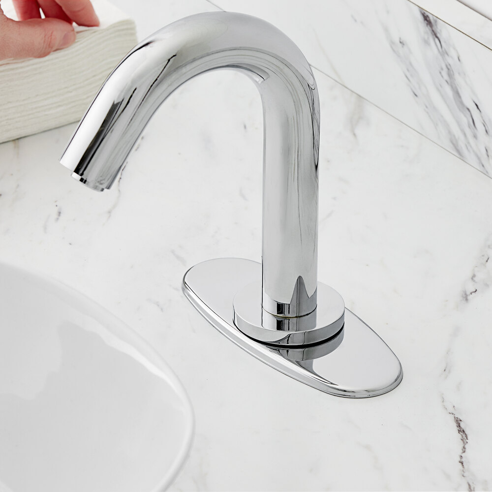 A chrome-plated oval faucet deck plate with a hole in the center.